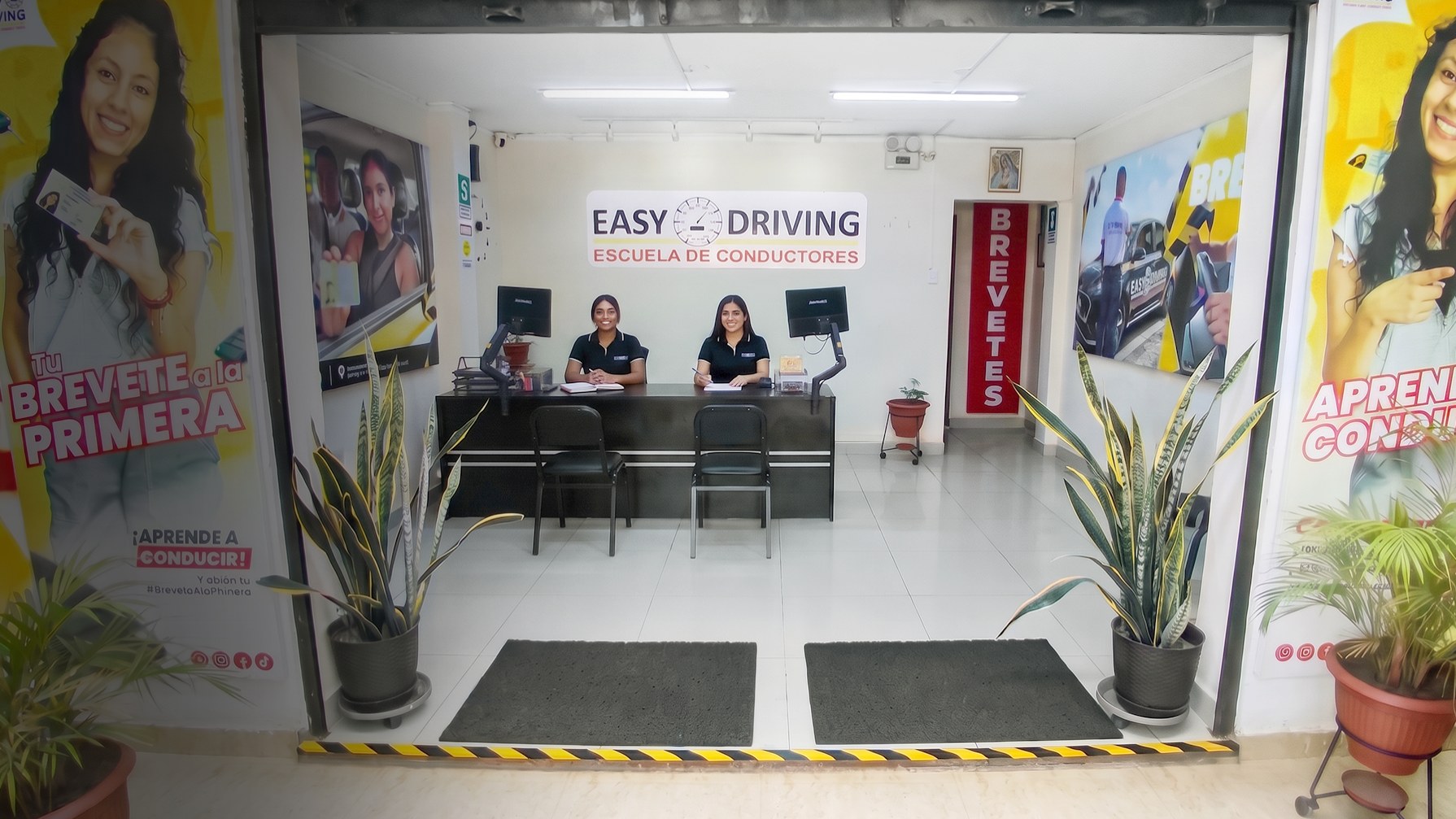Fachada de la sede Chiclayo de EasyDriving con autos de la escuela